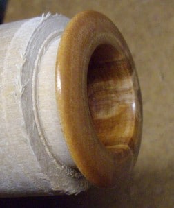 wooden grommet - finished and ready to be parted off the lathe