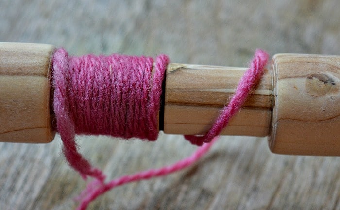 This shows the sett gauge in use to determine the number of wraps per inch of your yarn.